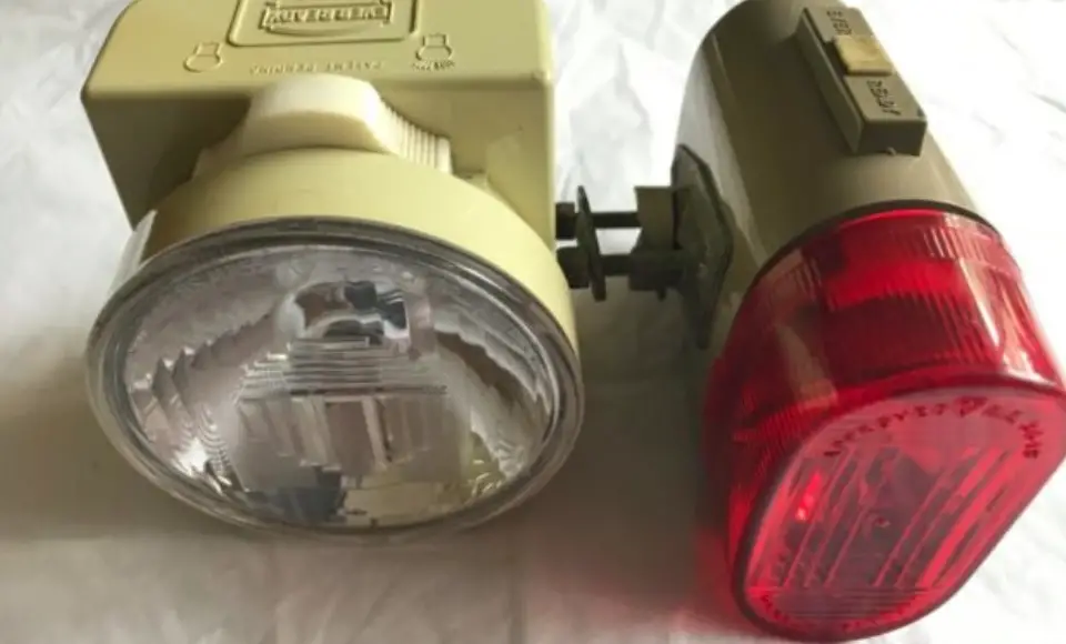 showing two retro bicycle lights or lamps from British Ever Ready circa 1975.  One front light and one back light in cream plastic.  The back light has a large red lens.